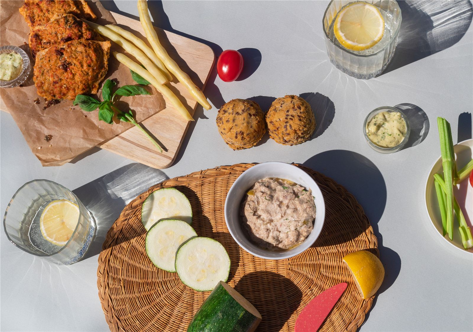 Keto kotleciki, pasta z tuńczyka, keto bułeczki i warzywa na stole